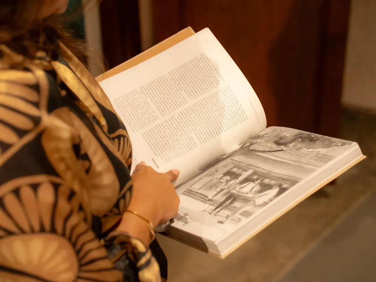 A reader browsing through historical photographs in The MTR Story