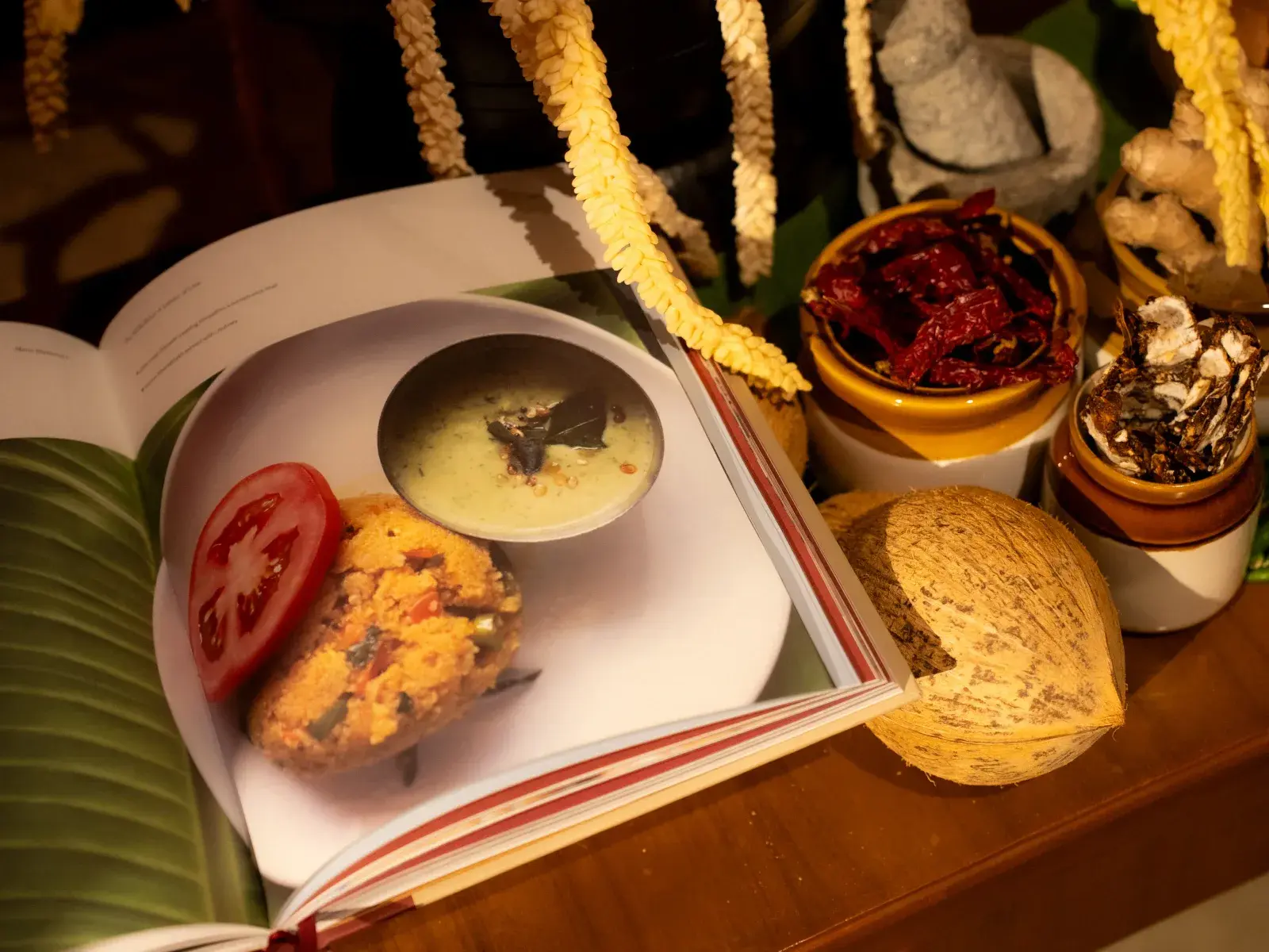 Open book showing MTR's signature dish photography with banana leaf and coconut